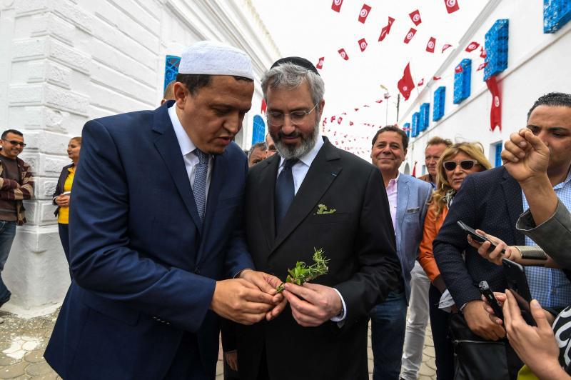 Hassen Chalghoumi (L), Imam of the municipal Drancy mosque in Seine-Saint-Denis, greets Paris’ rabbi Moshe Sebbag (C) at the Ghriba Synagogue on the Tunisian resort island of Djerba