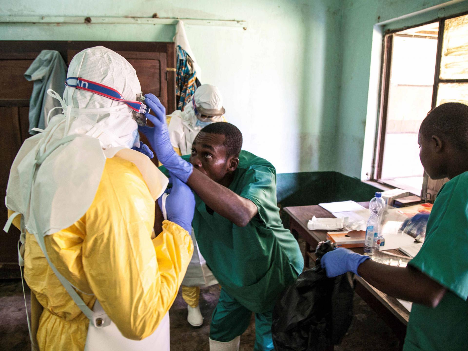 عاملون في مجال الصحة يرتدون معدات الوقاية أثناء تحضيرهم لاستقبال مشتبه بإصابتهم بإيبولا