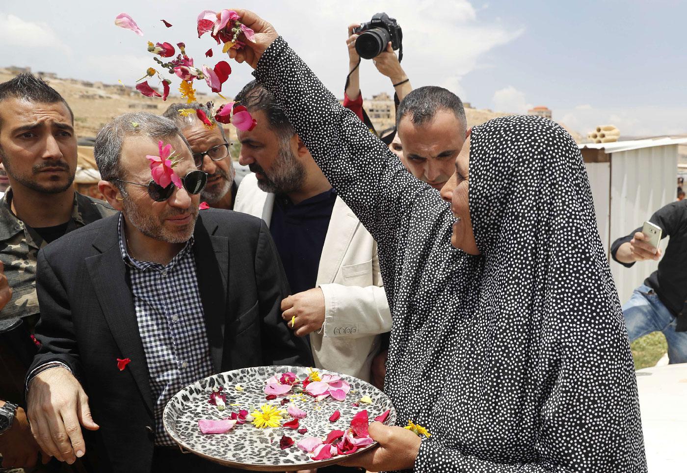 Gebran Bassil (C) is greeted with flower petals at a Syrian refugee camp in the town of Arsal on the eastern border with Syria.