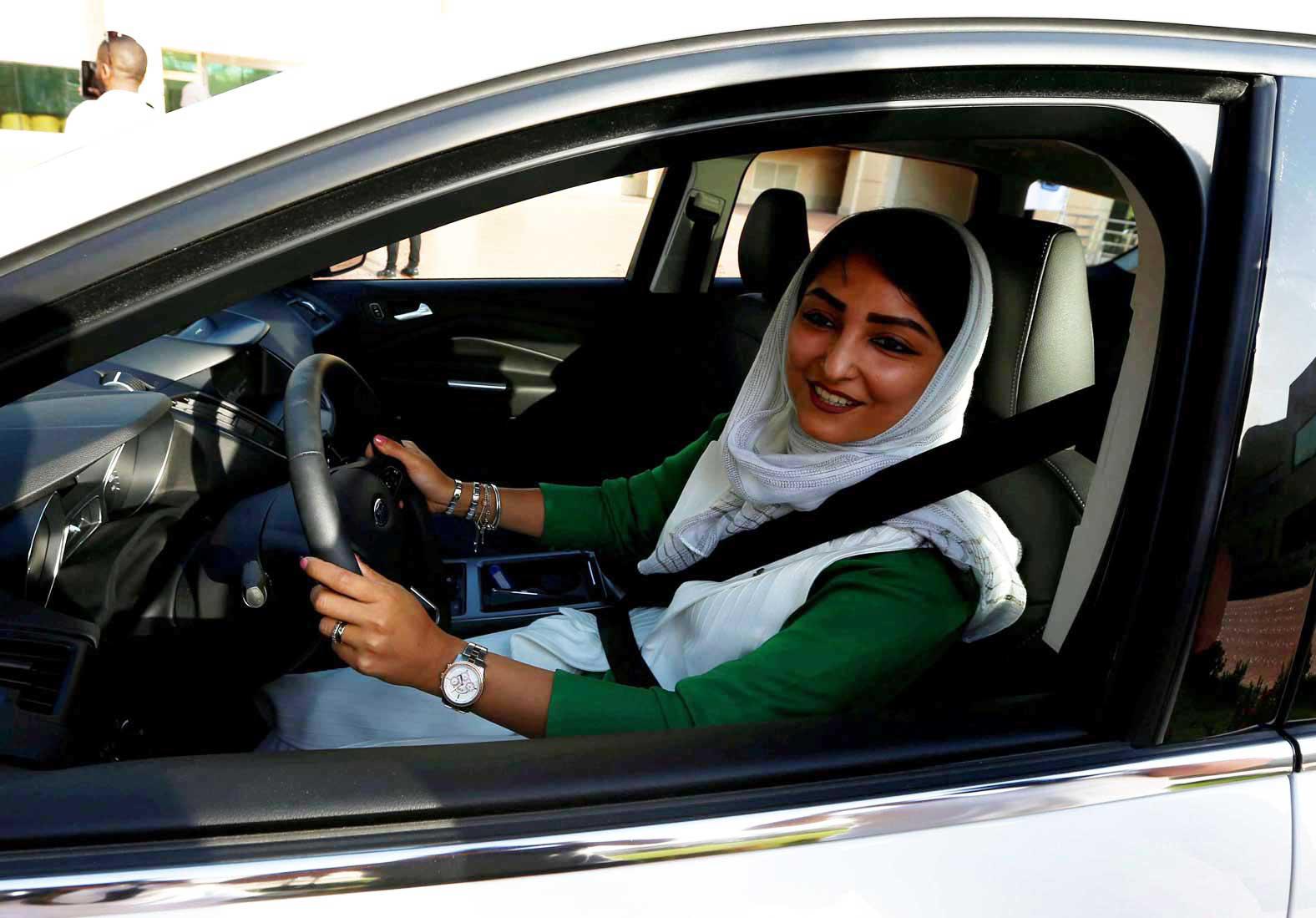   مرأة سعودية تبتسم خلف مقود سيارة