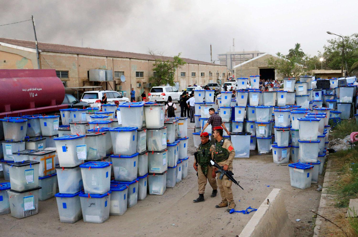 قوات الأمن العراقية تحرس صناديق انتخابية نجت من الحريق في بغداد