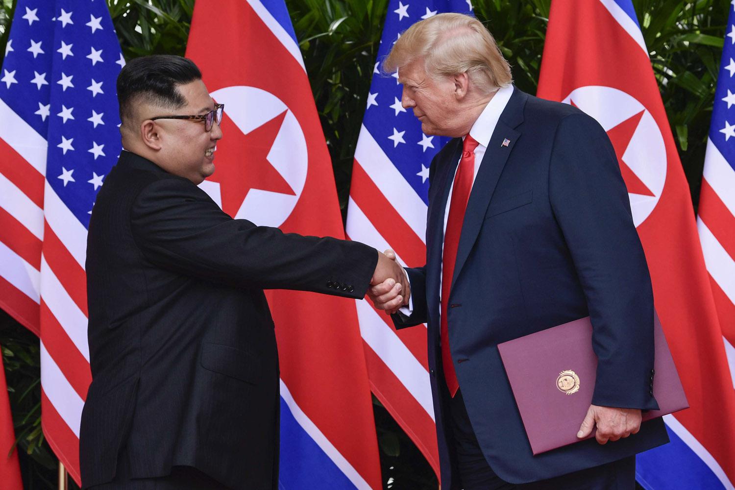 الرئيس الأميركي ترامب يصافح الزعيم الكوري الشمالي كيم
