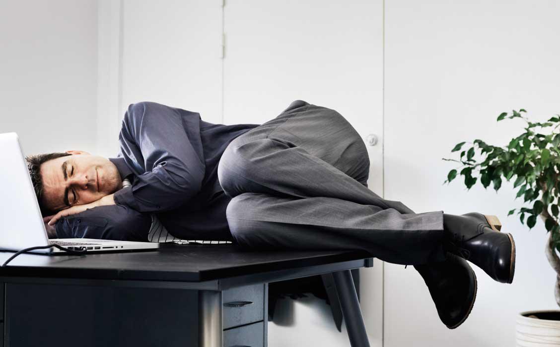 شخص ينام على مكتبه اثناء العمل