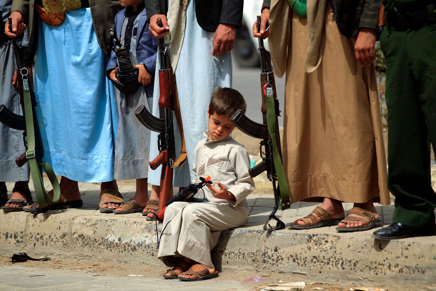 طفل يحمل لعبة على شكل سلاح في تجمع للحوثيين