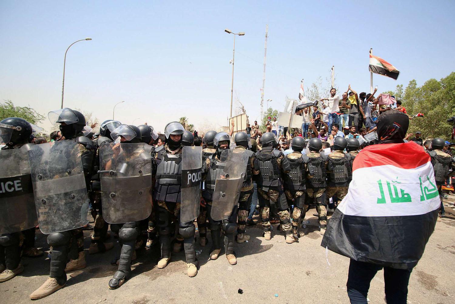 متظاهر عراقي أمام قوات مكافحة الشغب