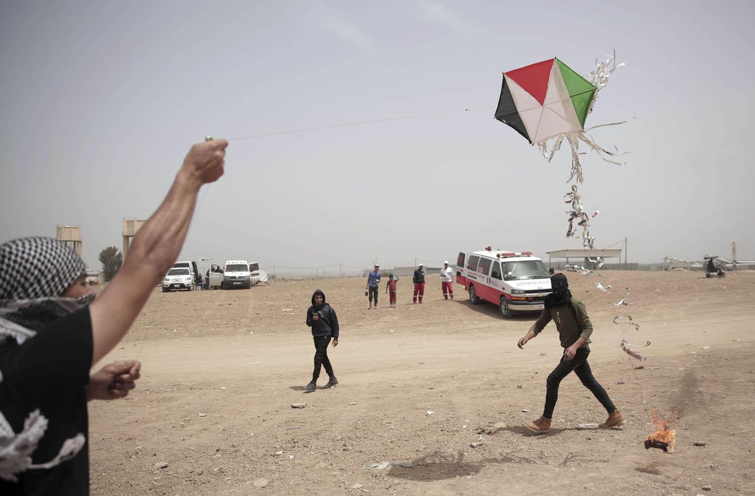 طفل فلسطيني يطير طائرة ورقية تحمل مادة حارقة على الحدود بين غزة واسرائيل