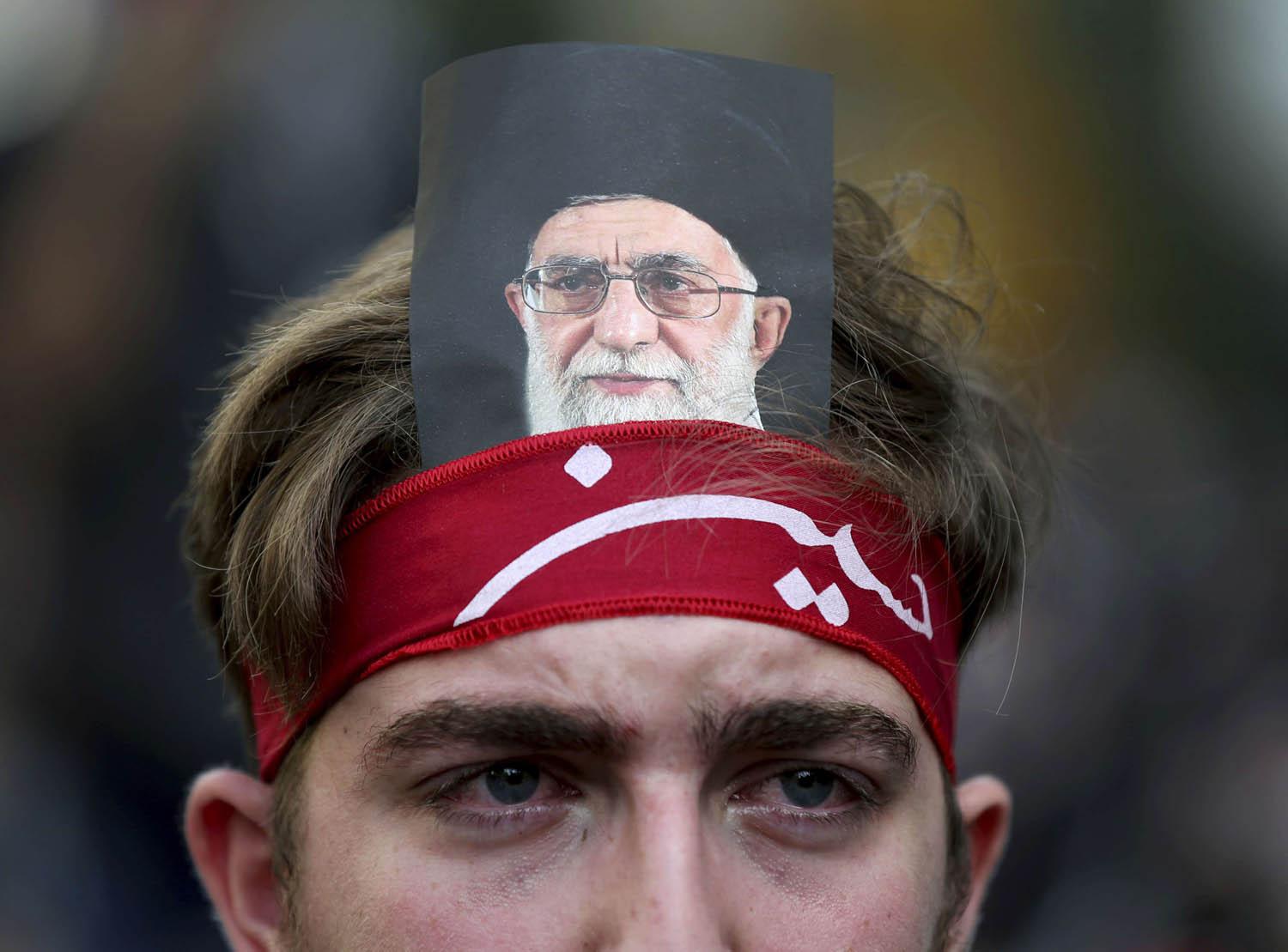 لبناني يضع صورة المرشد الأعلى الايراني خامنئي على رأسه