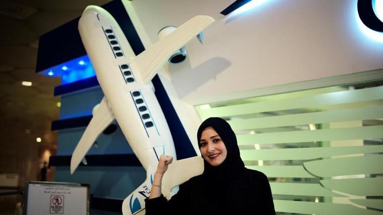 مرأة  سعودية قرب مجسم طائرة 