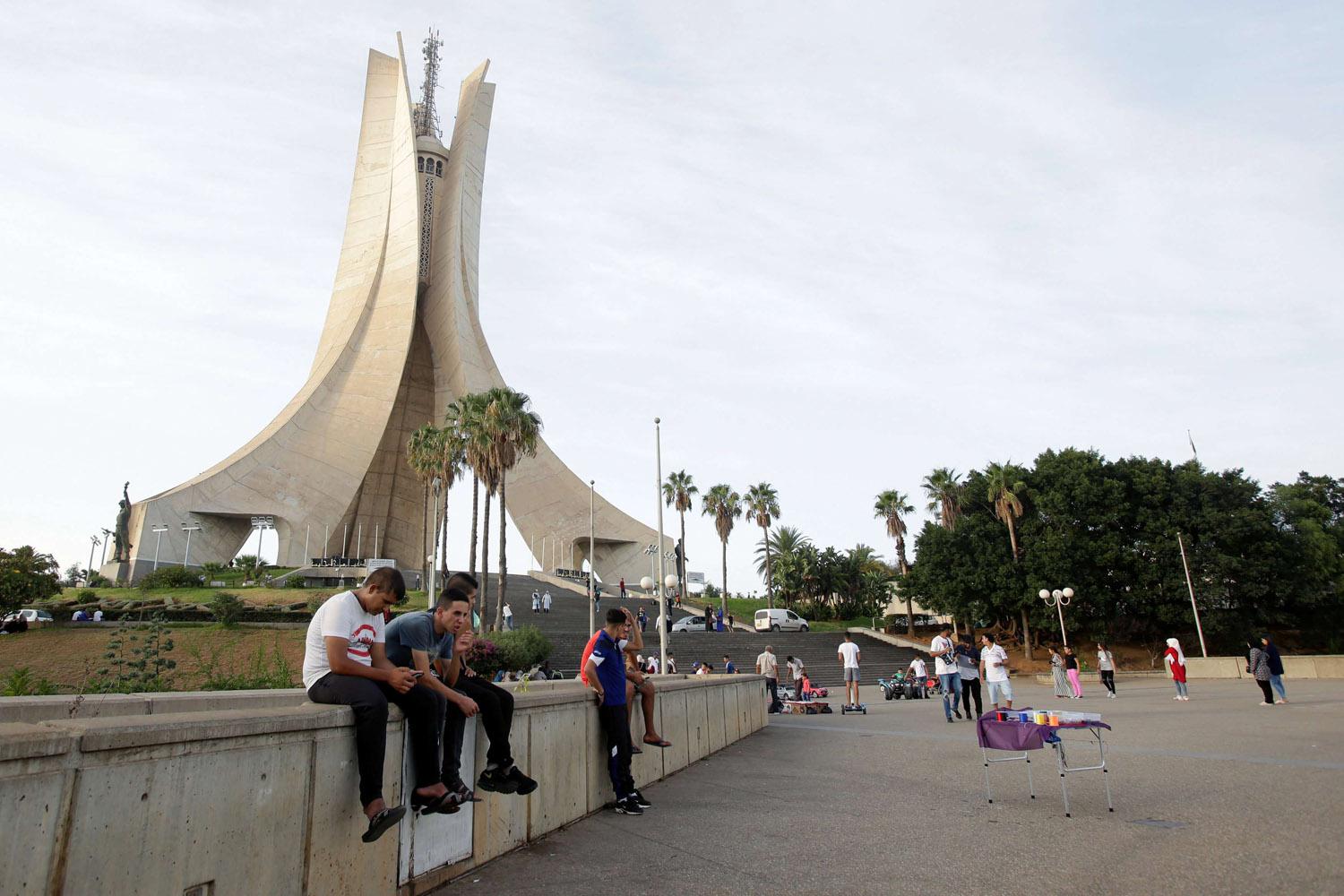شباب جزائريون يجلسون بالقرب من نصب الشهداء في العاصمة الجزائر