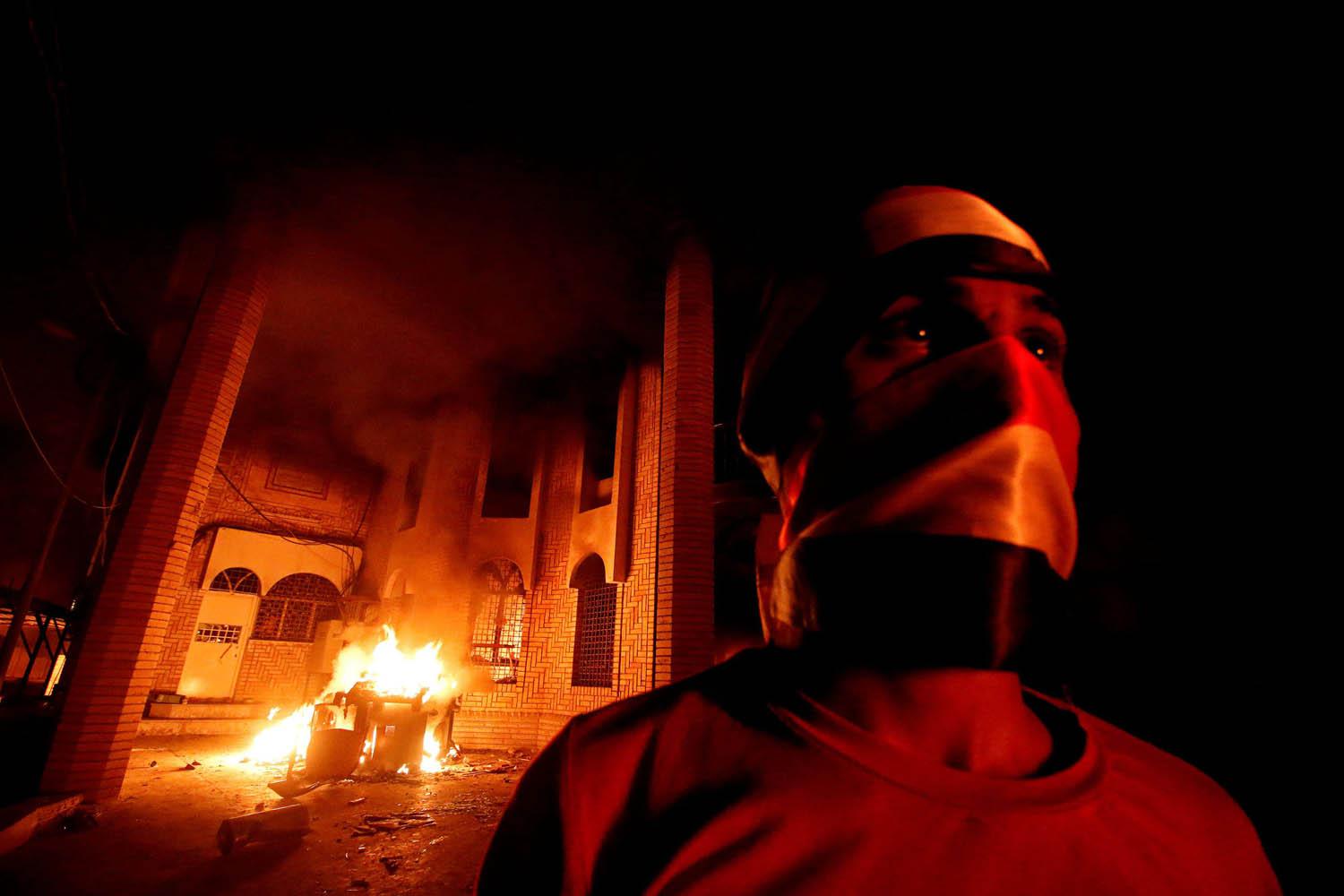 عراقي أمام القنصلية الإيرانية المحترقة في البصرة