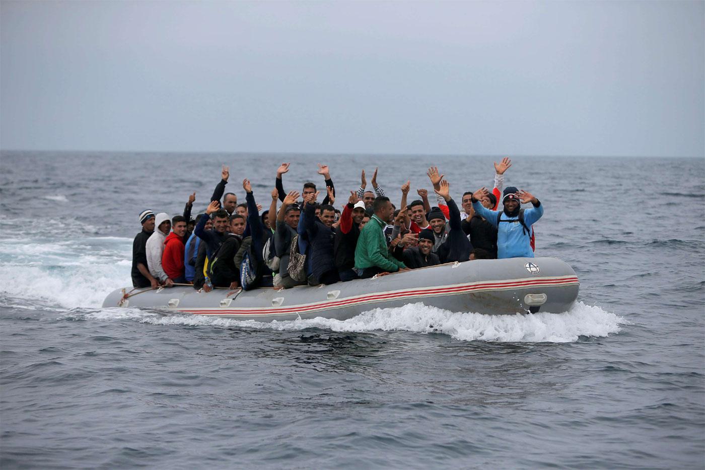 Migrants are seen on a dinghy as they cross the Strait of Gibraltar sailing from the coast of Morocco