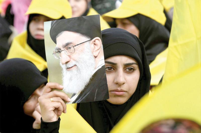 A Hezbollah supporter carries a picture of Iranian Supreme Leader Ayatollah Ali Khamenei during a rally in the Bekaa Valley, last May