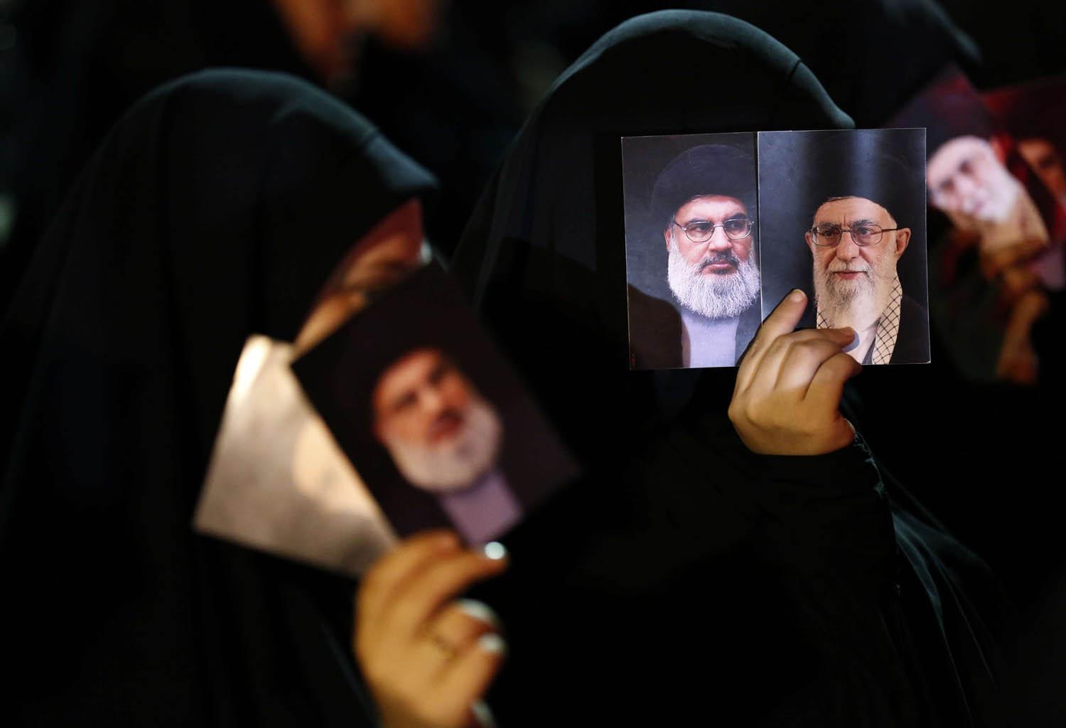 ناشطات من حزب الله يرفعون صورة خامنئي ونصرالله