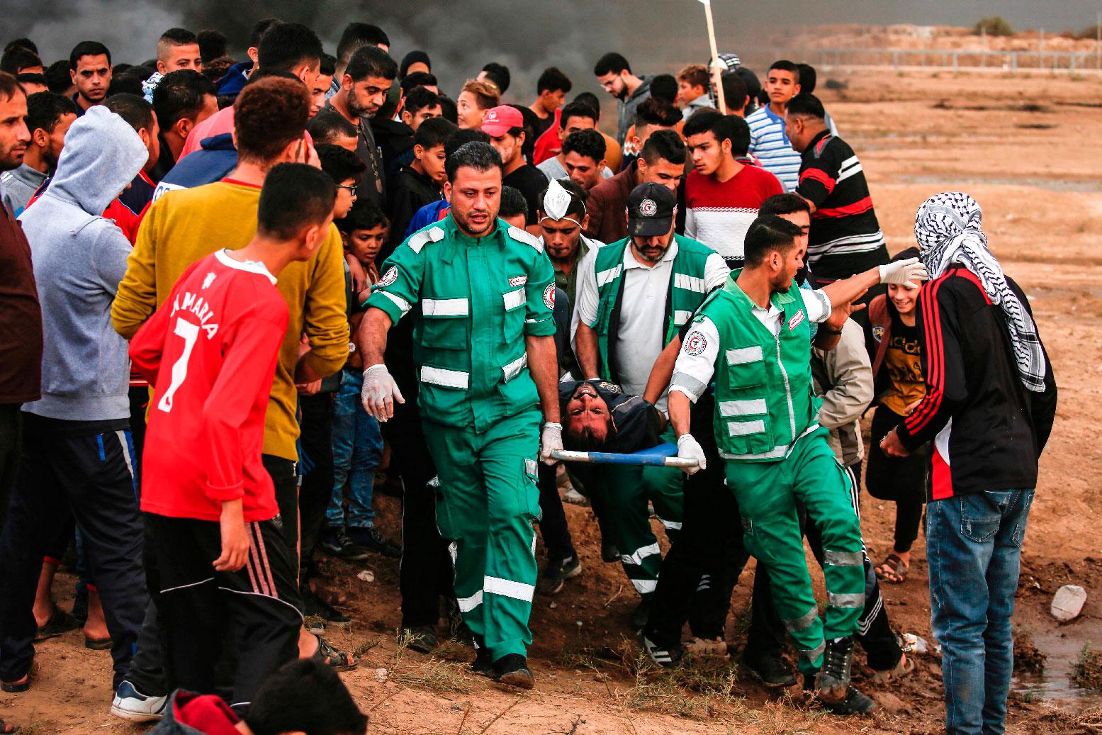 Palestinian paramedics carry away on a stretcher a protester who was injured during protests.
