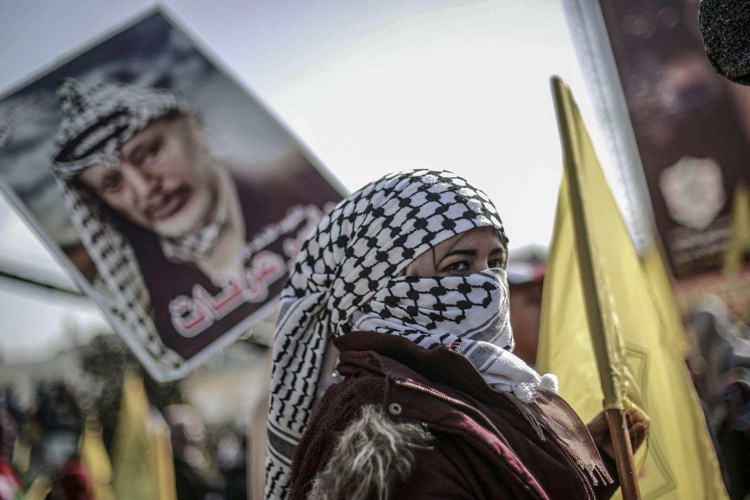 فلسطينيون يرفعون صورة عرفات في ذكرى رحيله