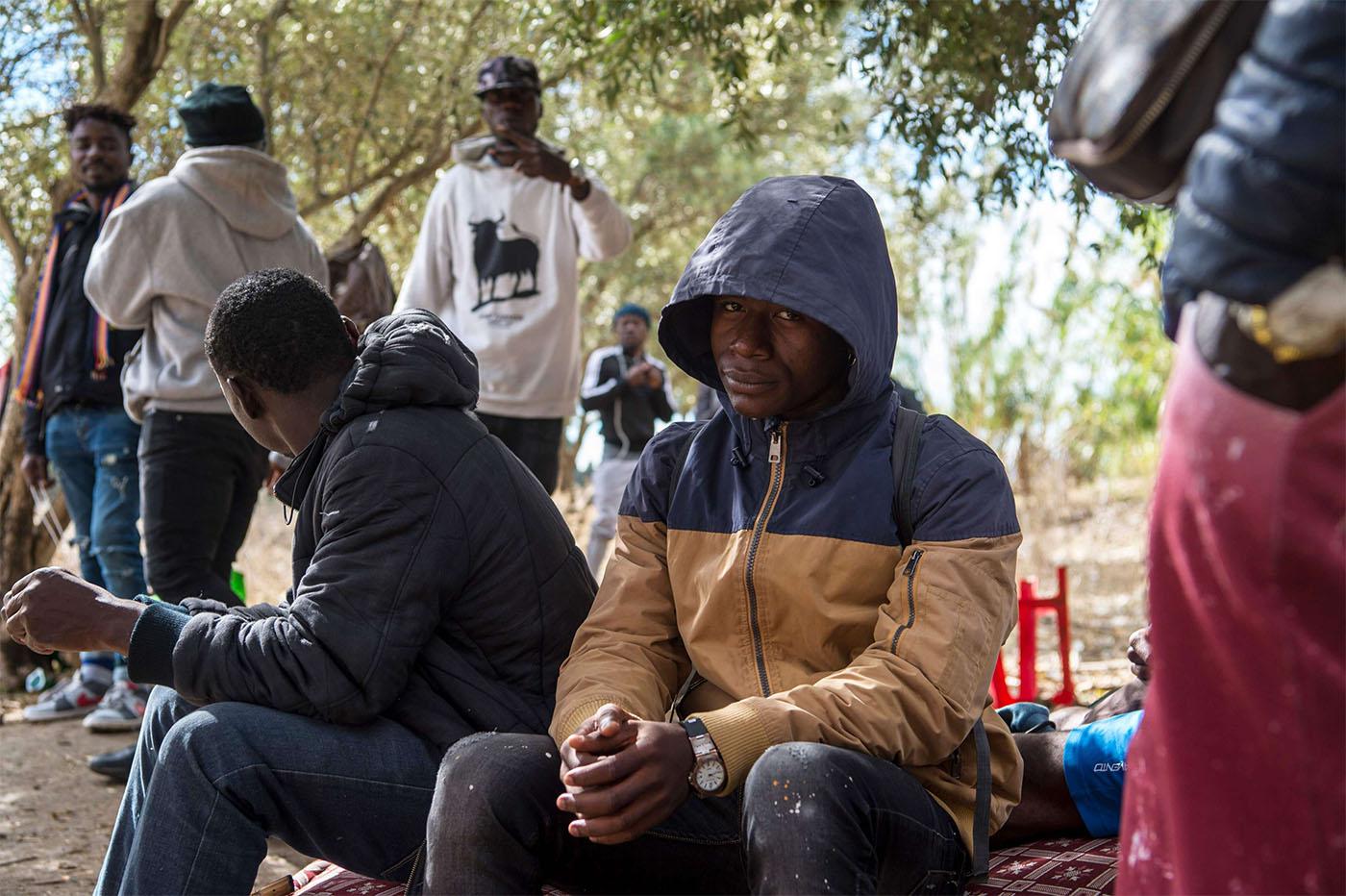 Migrants from Sub-Saharan Africa take shelter while hiding from the police in a forest in the district of Boukhalef of Tangiers
