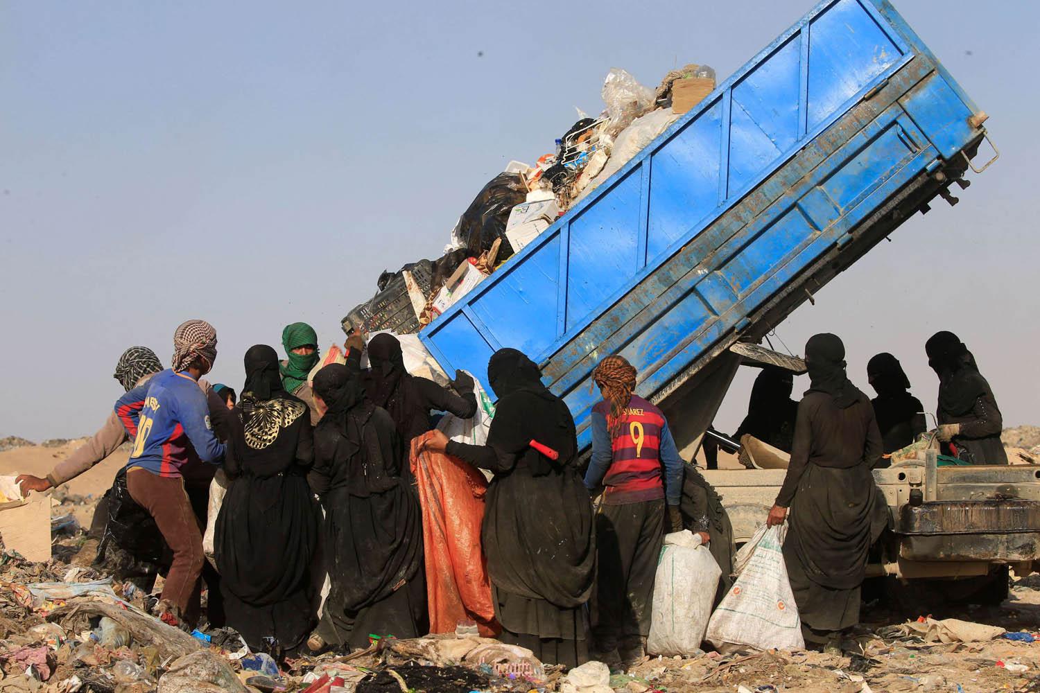عراقيات ينتظرن رمي الزبالة للعثور على ما يمكن بيعه منها