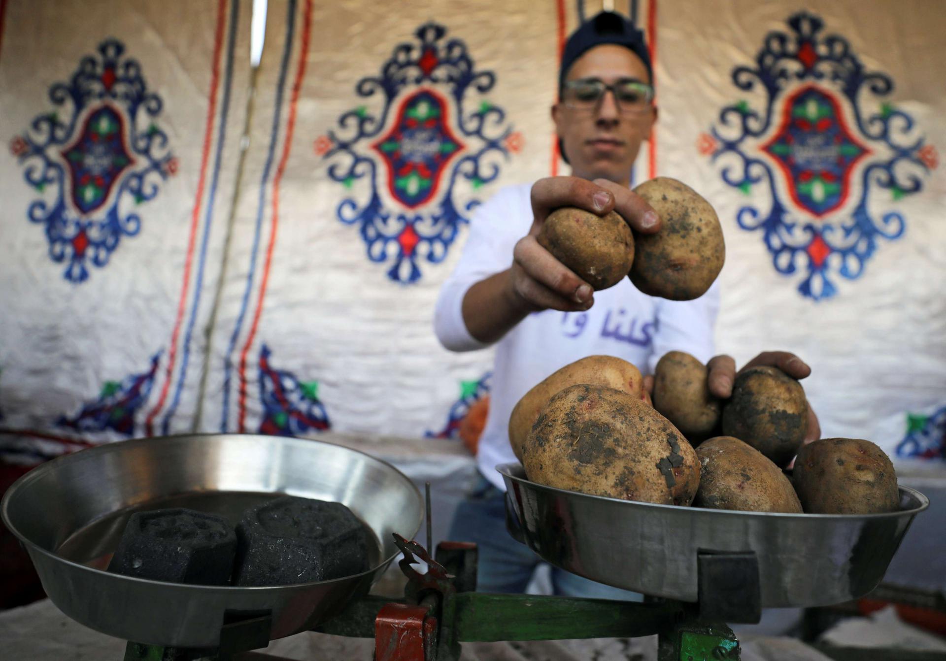 A vendor weighs potatoes at a temporary tent with government subsidised goods, after consumer prices increase across the country in Cairo, Egypt.