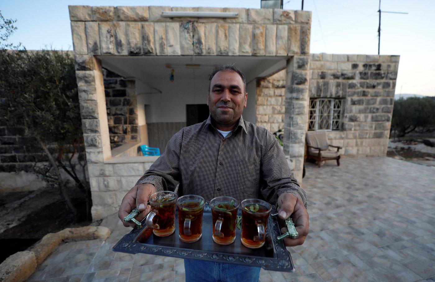 The uncle of Rashida Tlaib, the first Palestinian-American woman to be elected to the U.S. Congress, offers tea after her victory, in Beit Ur Al-Fauqa, in the occupied West Bank November 7, 2018. 