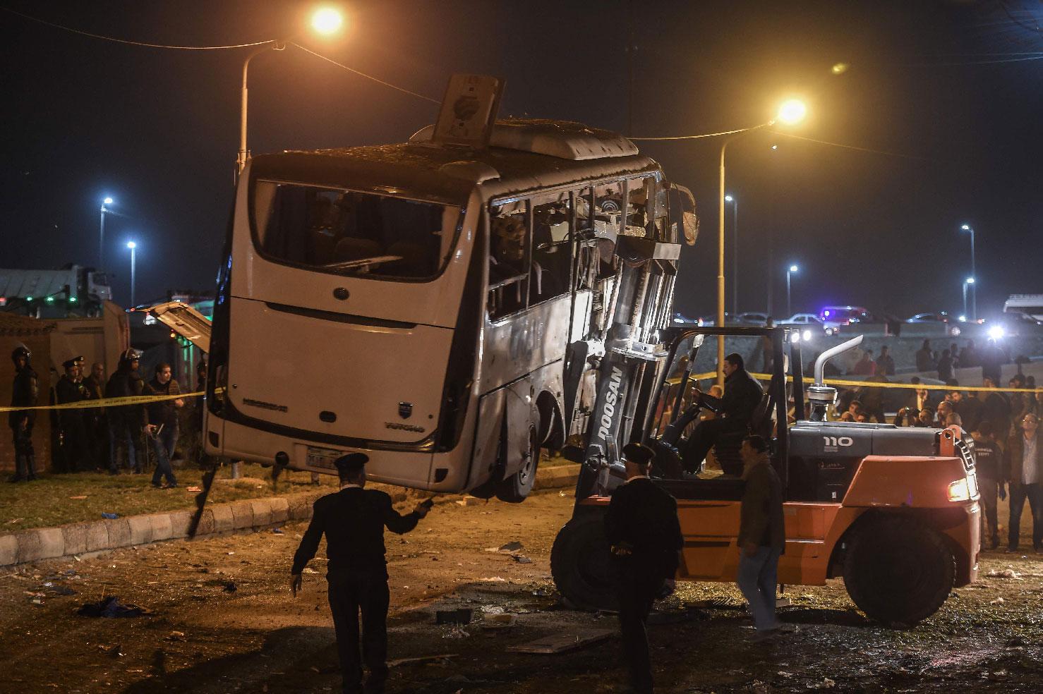A damaged tourist bus is being removed after it was struck by a roadside bomb near the Pyramids of Giza at the district of al-Maryutia, on December 28, 2018. 