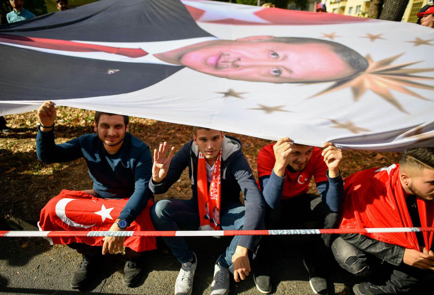 شباب ألمان من أصول تركية ينتظرون مرور موكب الرئيس التركي رجب طيب أردوغان في كولون