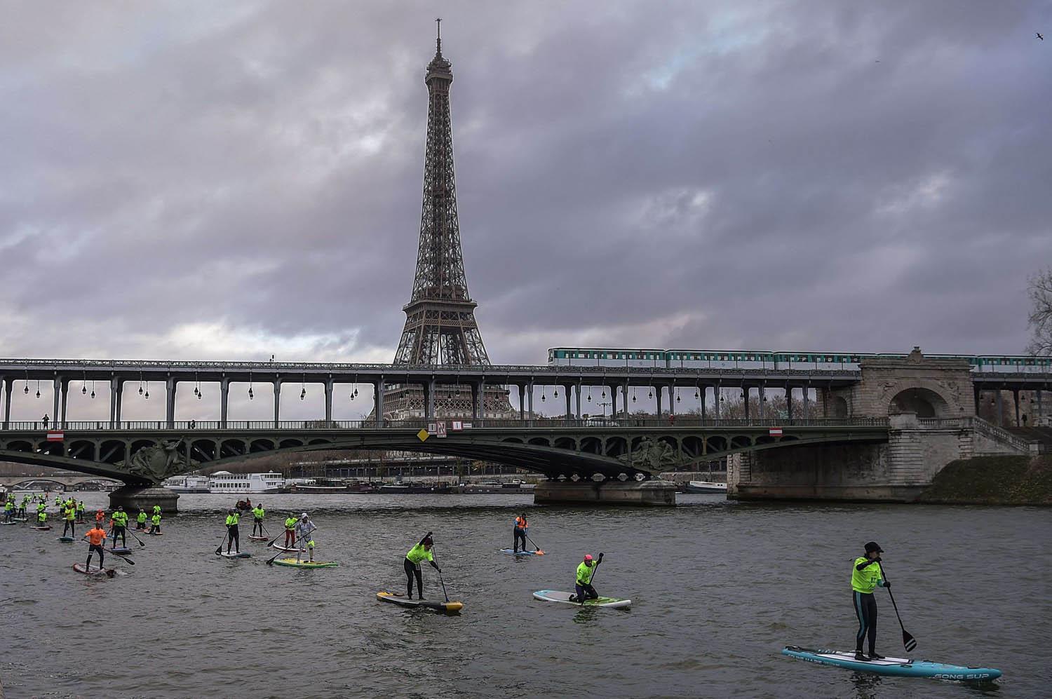متسابقون يرتدون سترات صفراء يجولون نهر السين في باريس