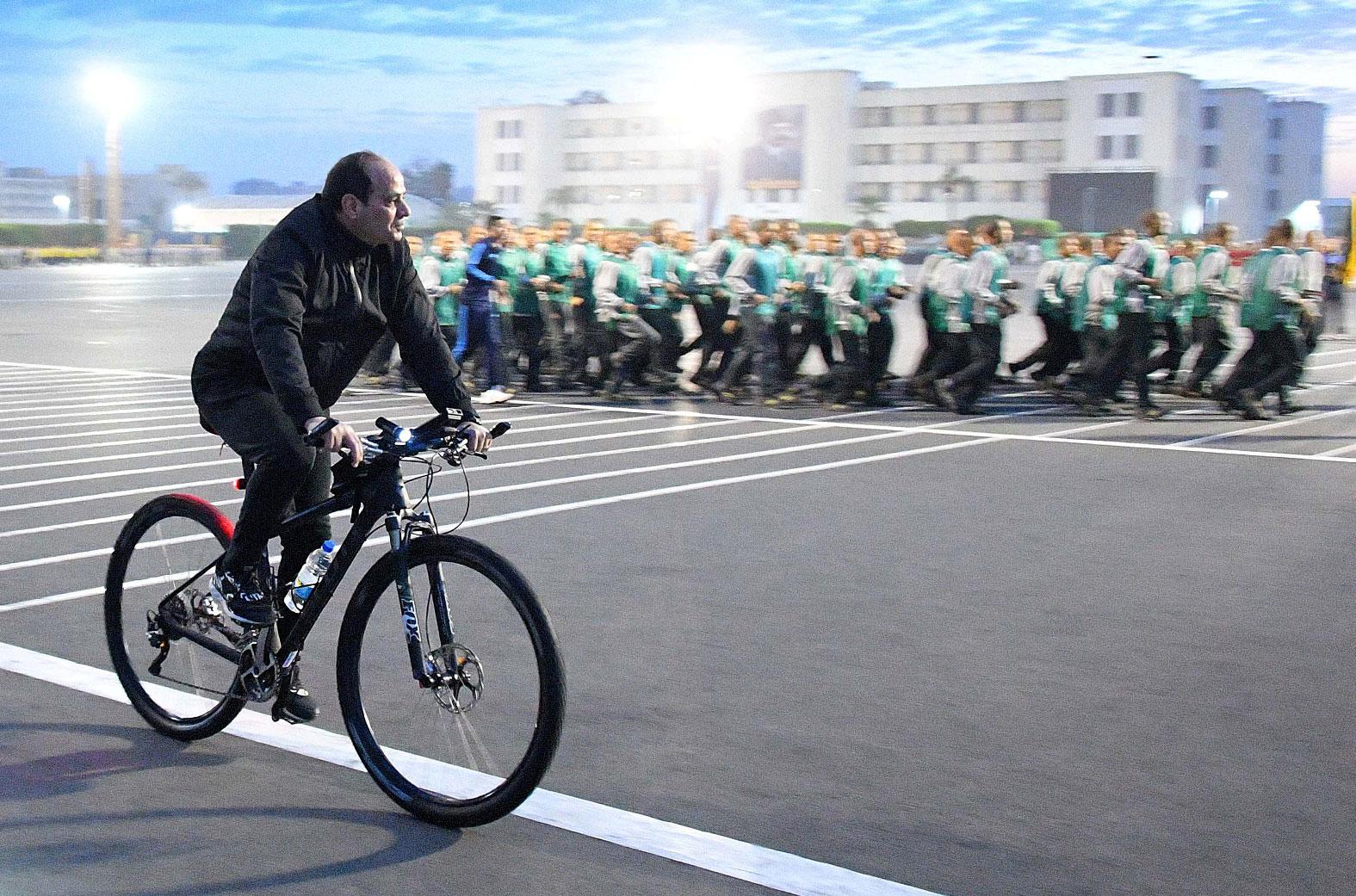 Egyptian President Abdel Fattah Al Sisi rides a bicycle during a follow-up on training and rehabilitation programs at the Military Academy in Cairo, Egypt, February 19, 2018.