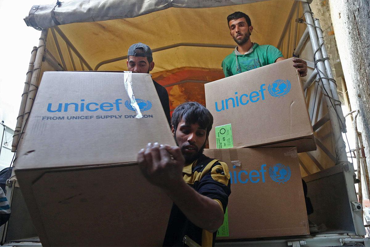 Syrians unload aid packages at al-Nashabia in the rebel-held Eastern Ghouta region