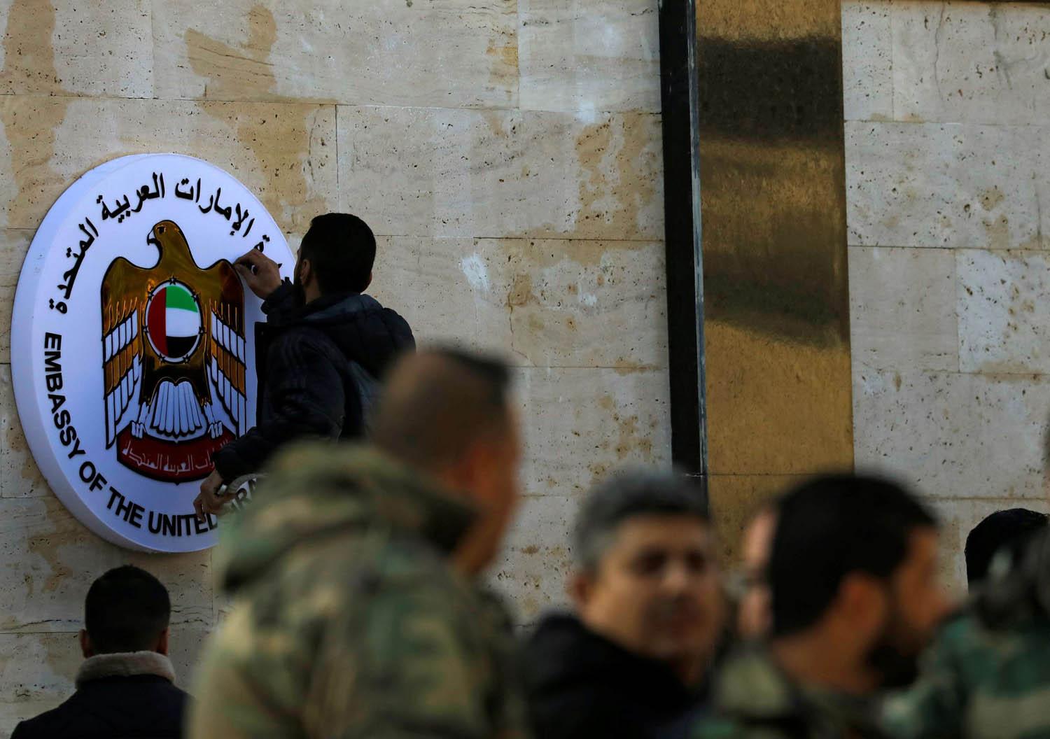 فني يركب شعار سفارة الامارات على واجهة السفارة في دمشق