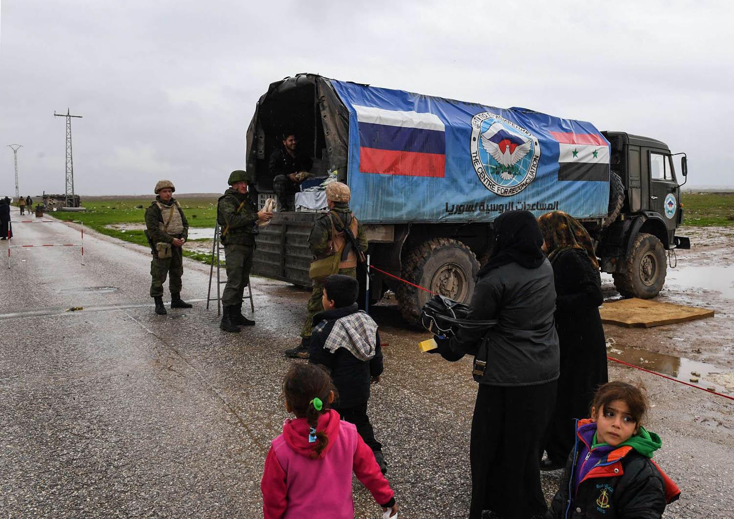 شاحنة مساعدات روسية توزع الأكل على اللاجئين السوريين في منطقة ادلب