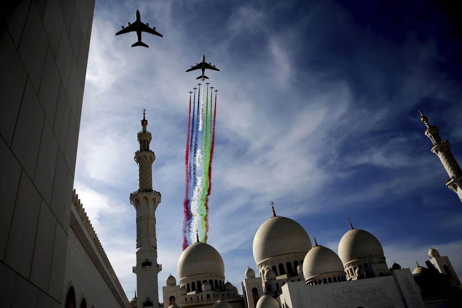 طائرات الاتحاد والامارات تستعرضان بصحبة فريق الفرسان في سماء مسجد الشيخ زايد في أبوظبي بمناسبة العيد الوطني في الإمارات