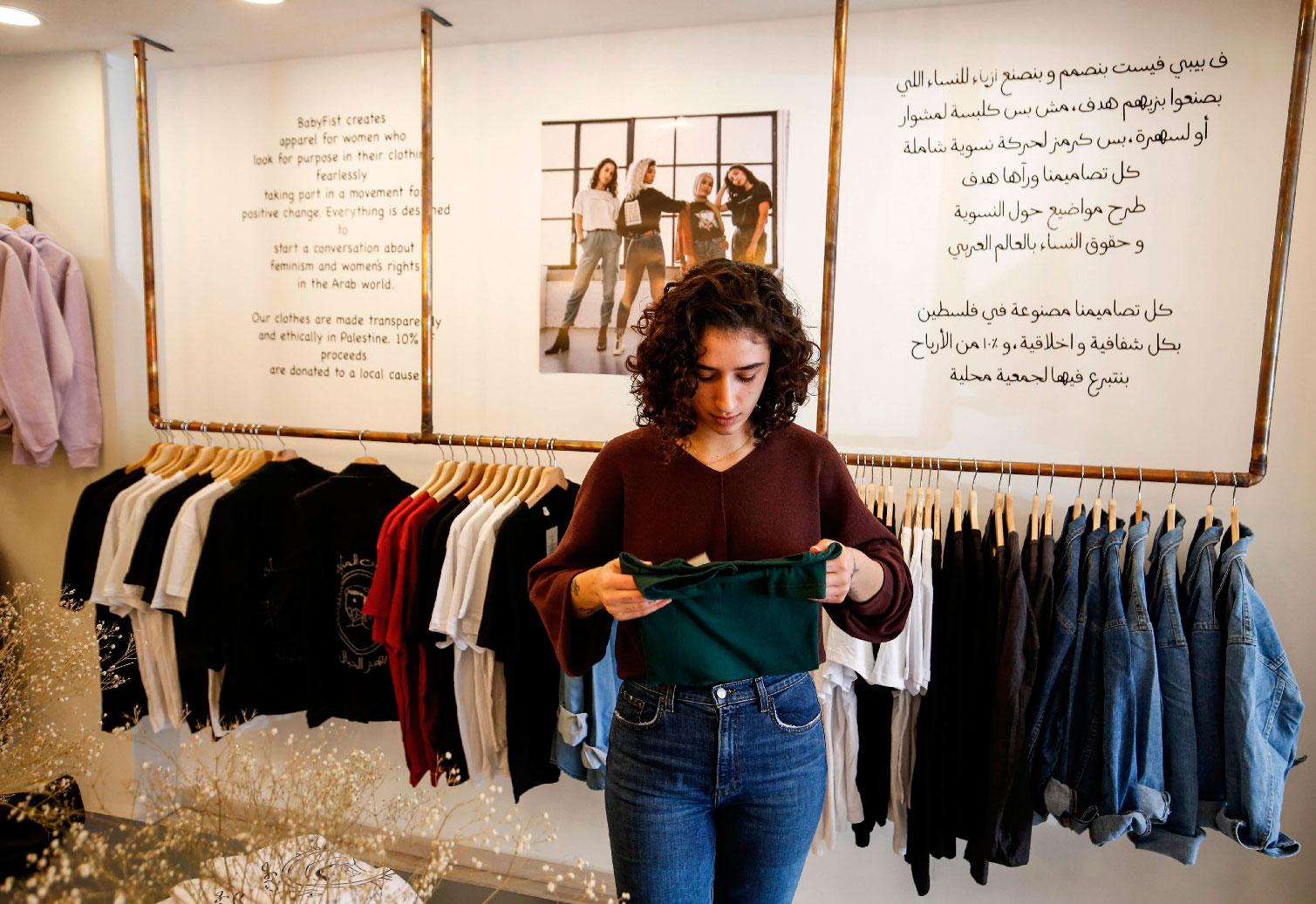 Palestinian fashion designer Yasmeen Mjalli speaks while standing in her clothing shop where her label collection "BabyFist" carrying anti-sexual harassment slogans is showcased, in Ramallah in the Israeli-occupied West Bank on December 19, 2018.