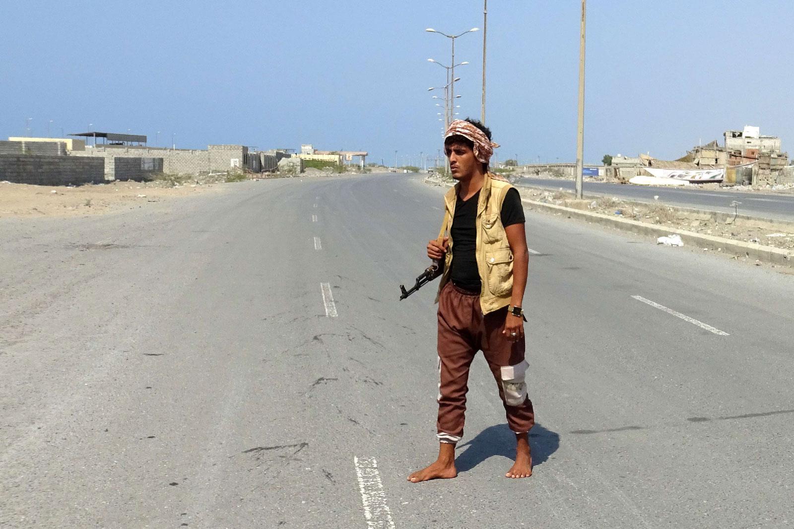 A member of the Yemeni pro-government forces walks with his rifle at the eastern entrance of the port city of Hodeidah on December 30, 2018