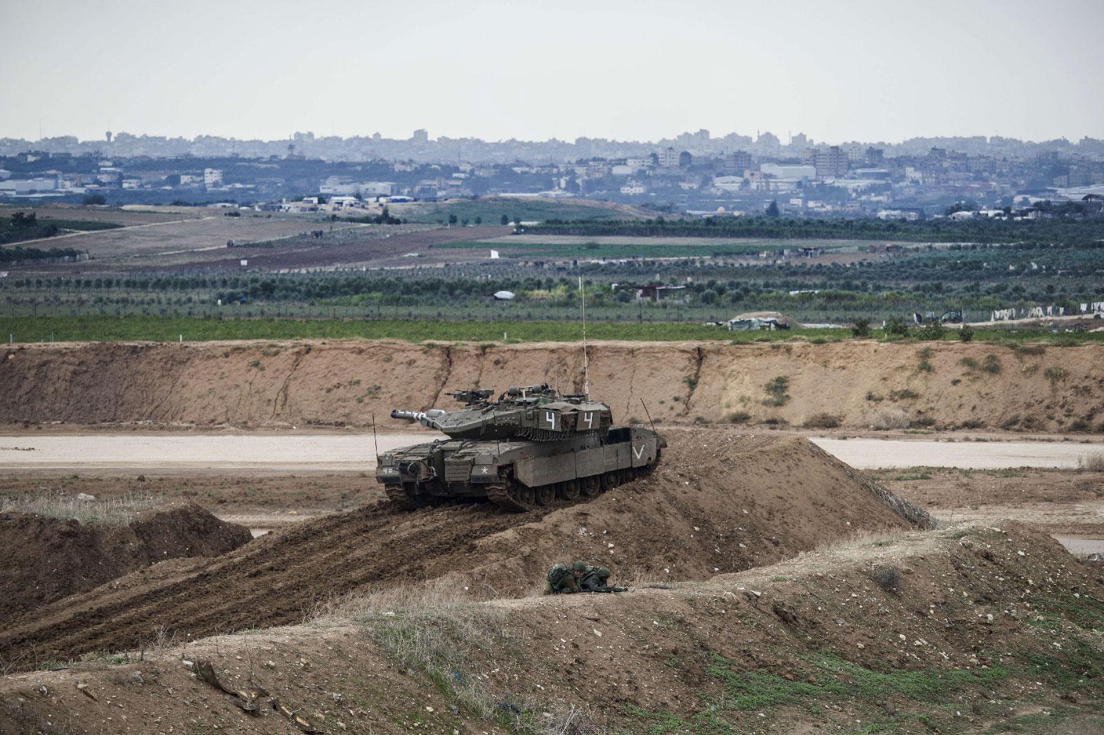 Israeli tank and soldiers take positions on the Israel Gaza border, Friday, Nov. 16, 2018.