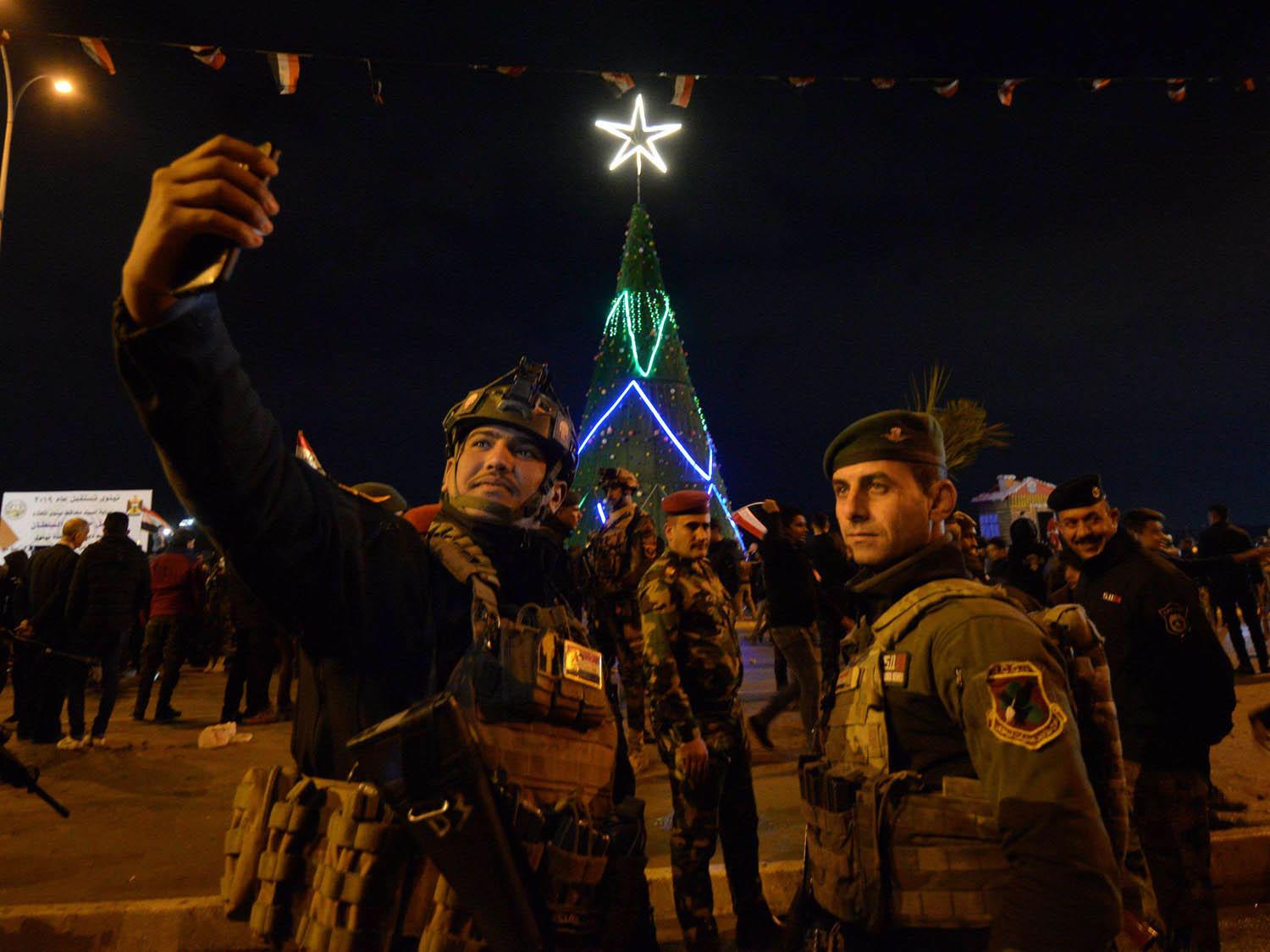 رجال أمن عراقيون في سلفي بالقرب من شجرة الميلاد وسط بغداد