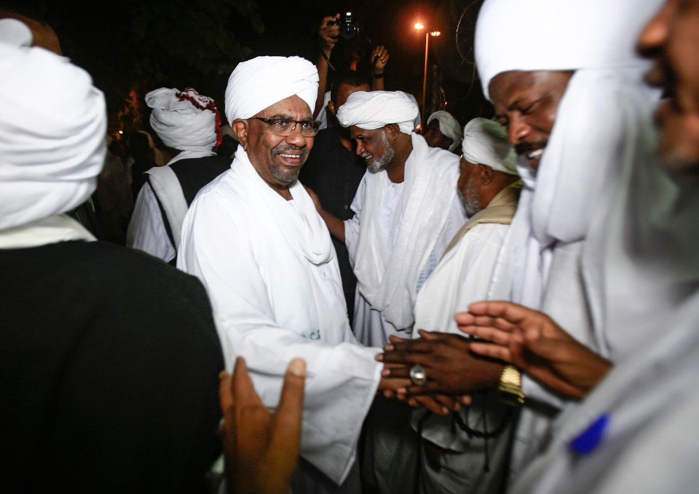 Sudanese President Omar al-Bashir shakes hands with Sufi Muslim clerics at the presidential palace in the capital Khartoum on January 3, 2019.