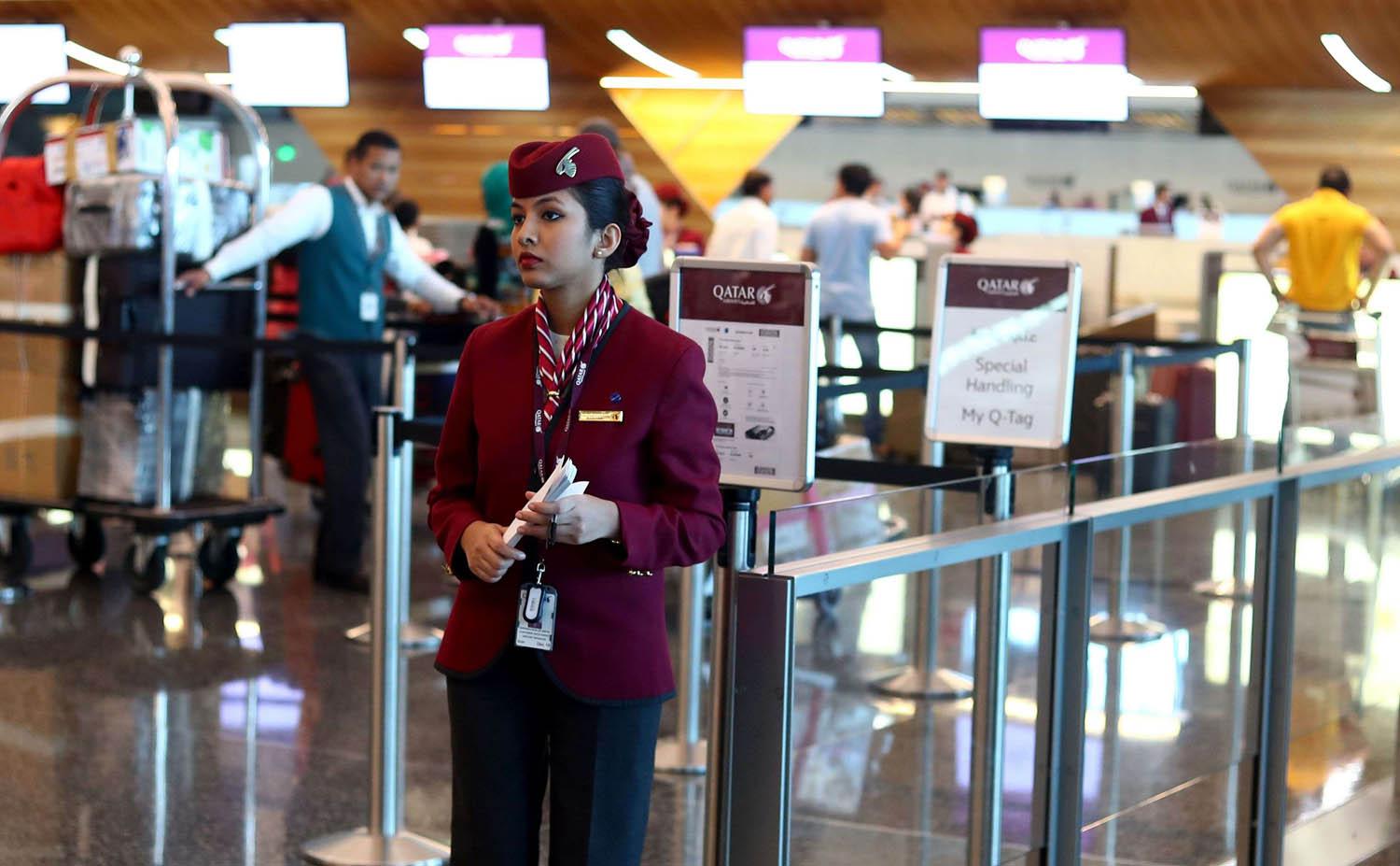 موظفة من الخطوط الجوية القطرية تنتظر الركاب في مطار الدوحة