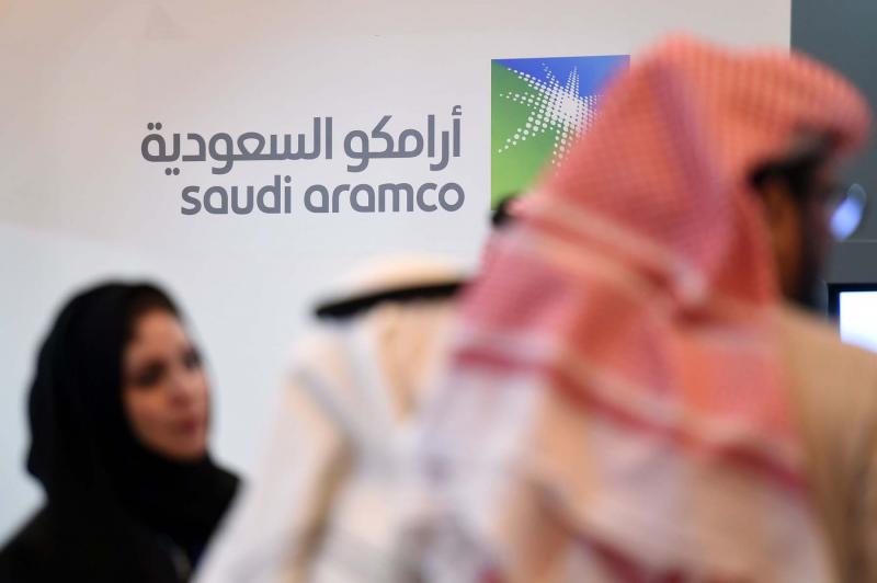 Engine of growth. Saudi and foreign investors stand in front of the logo of Aramco in Riyadh