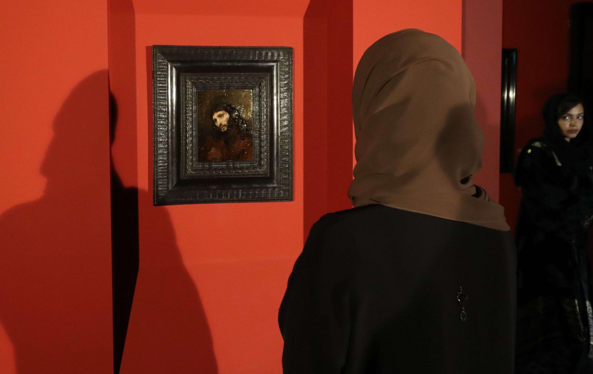 زائرة تتطلع للوحة 'رأس شاب' بعيد عرضها في لوفر أبوظبي