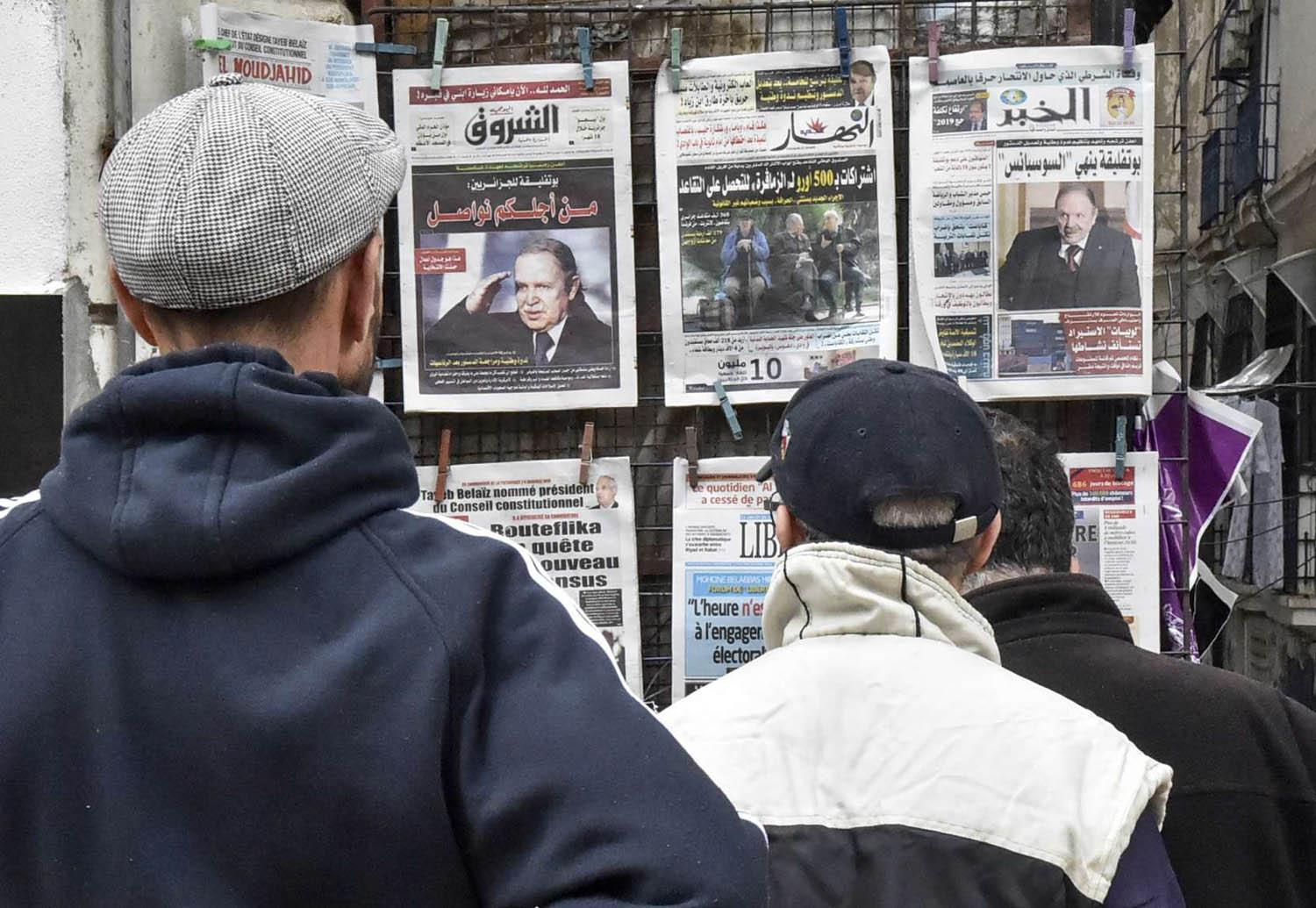 جزائريون يطالعون الصفحات الأولى لجرائد تعلن ترشح الرئيس