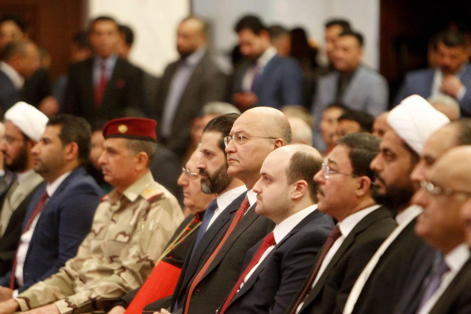 الرئيس العراقي برهم صالح يتوسط مجموعة من السياسيين في العراق في حفل ببغداد