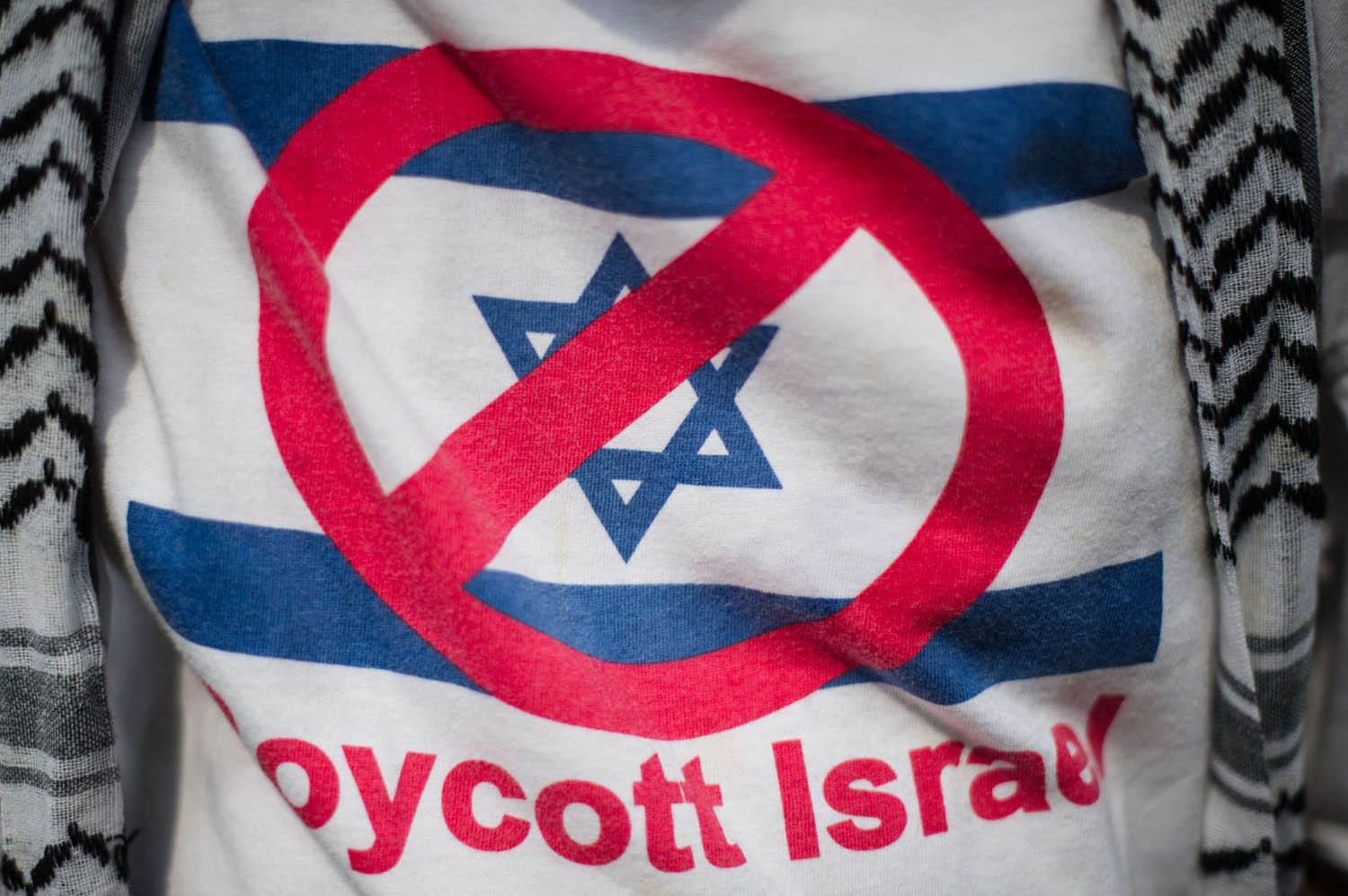متظاهر يرتدي قميصا يحمل علامة مقاطعة إسرائيل في كوالالامبور