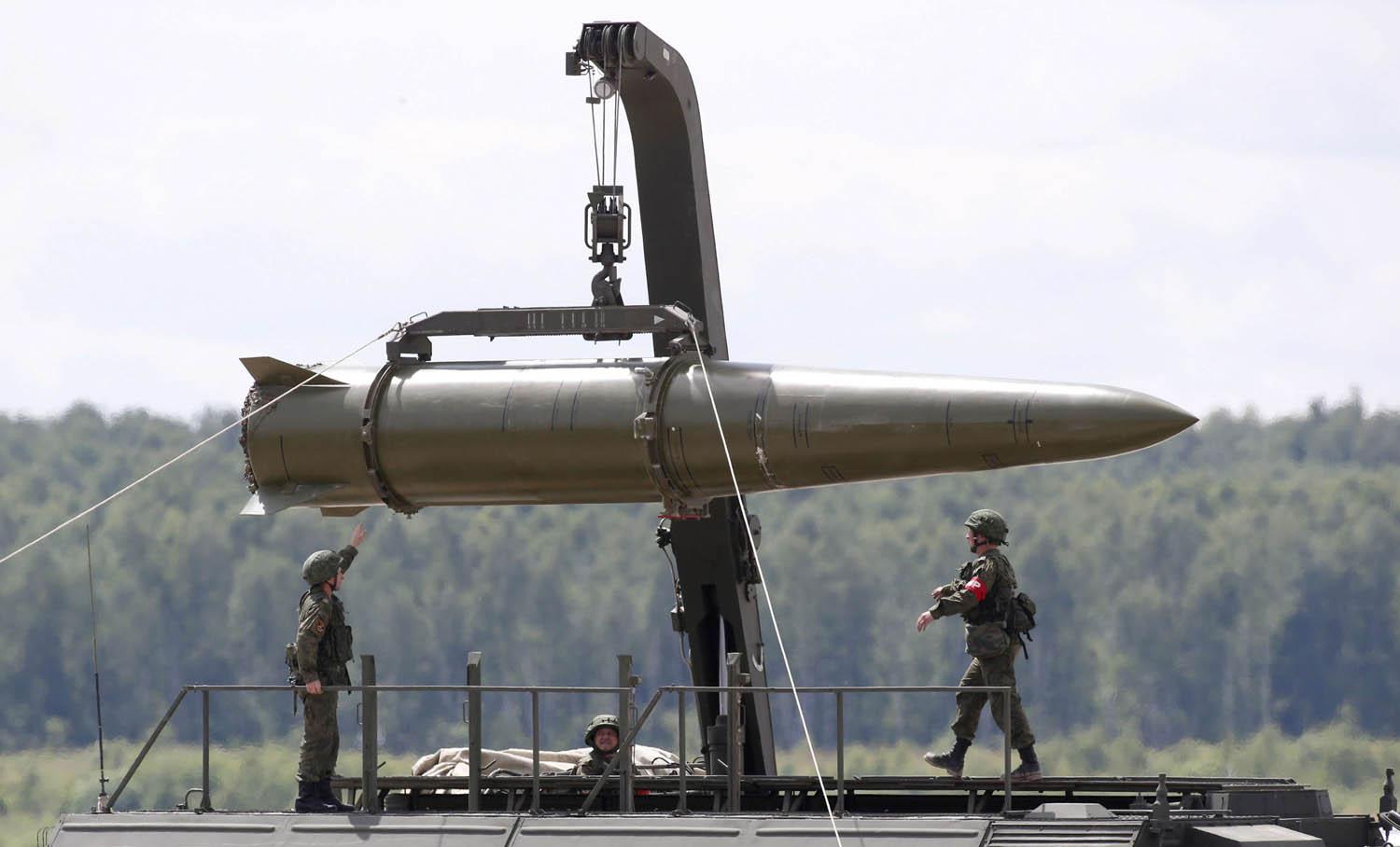 جنود روس يحملون صاروخا تكتيكيا من طراز اسكندر على حاملة صواريخ