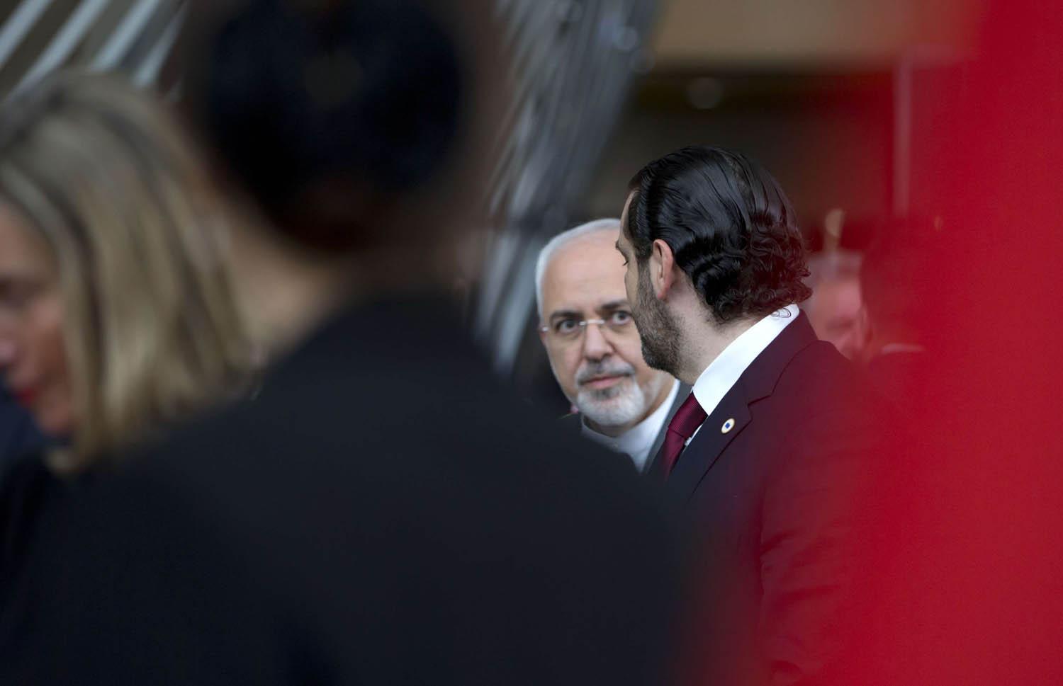 رئيس الوزراء اللبناني سعد الحريري ينظر إلى وزير الخارجية الإيراني محمد جواد ظريف في لقاء ببروكسيل
