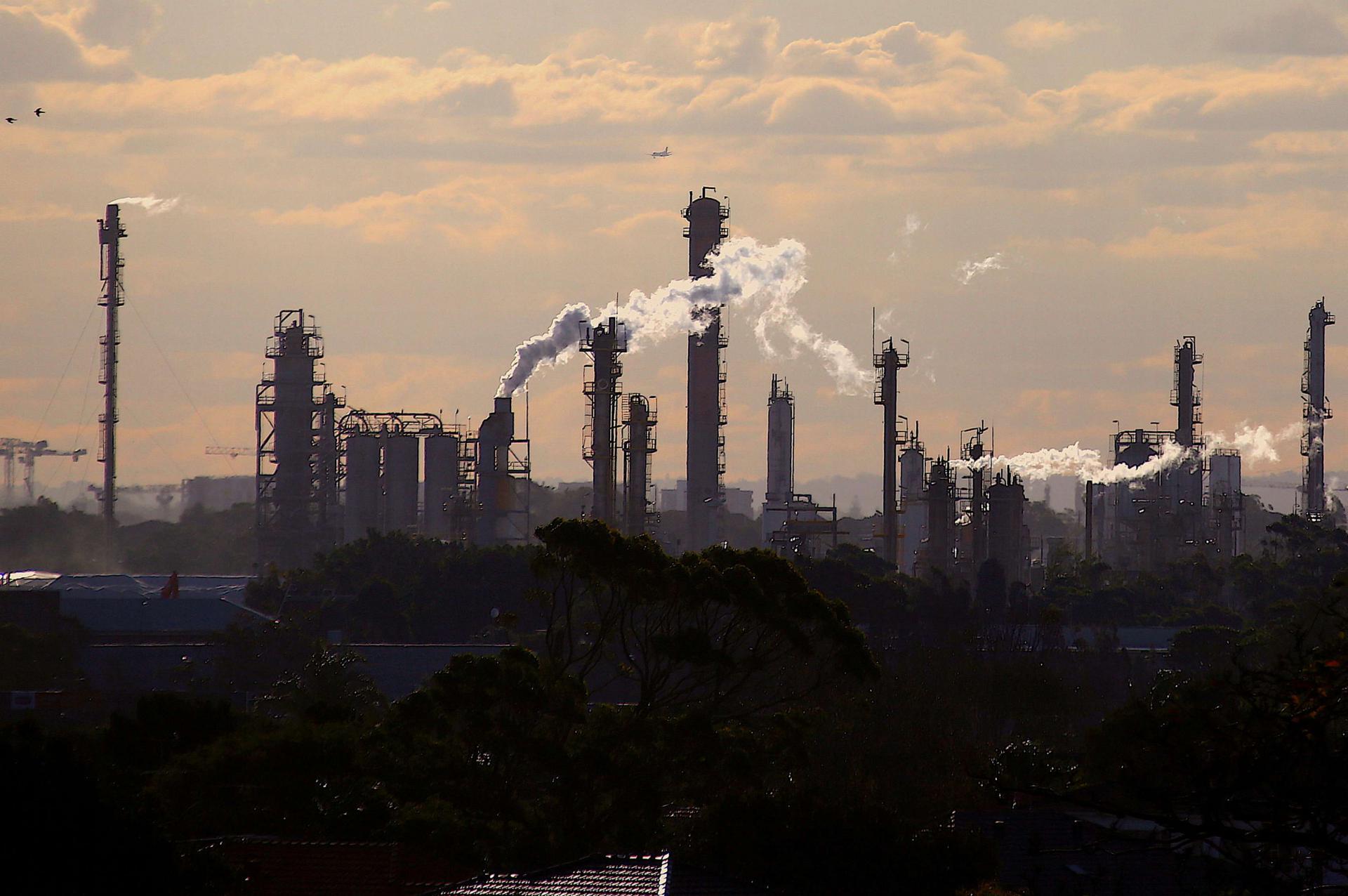 طيور وطائرة تحلق فوق الانبعاثات من مداخن مصنع كيماوي في سيدني بأستراليا 