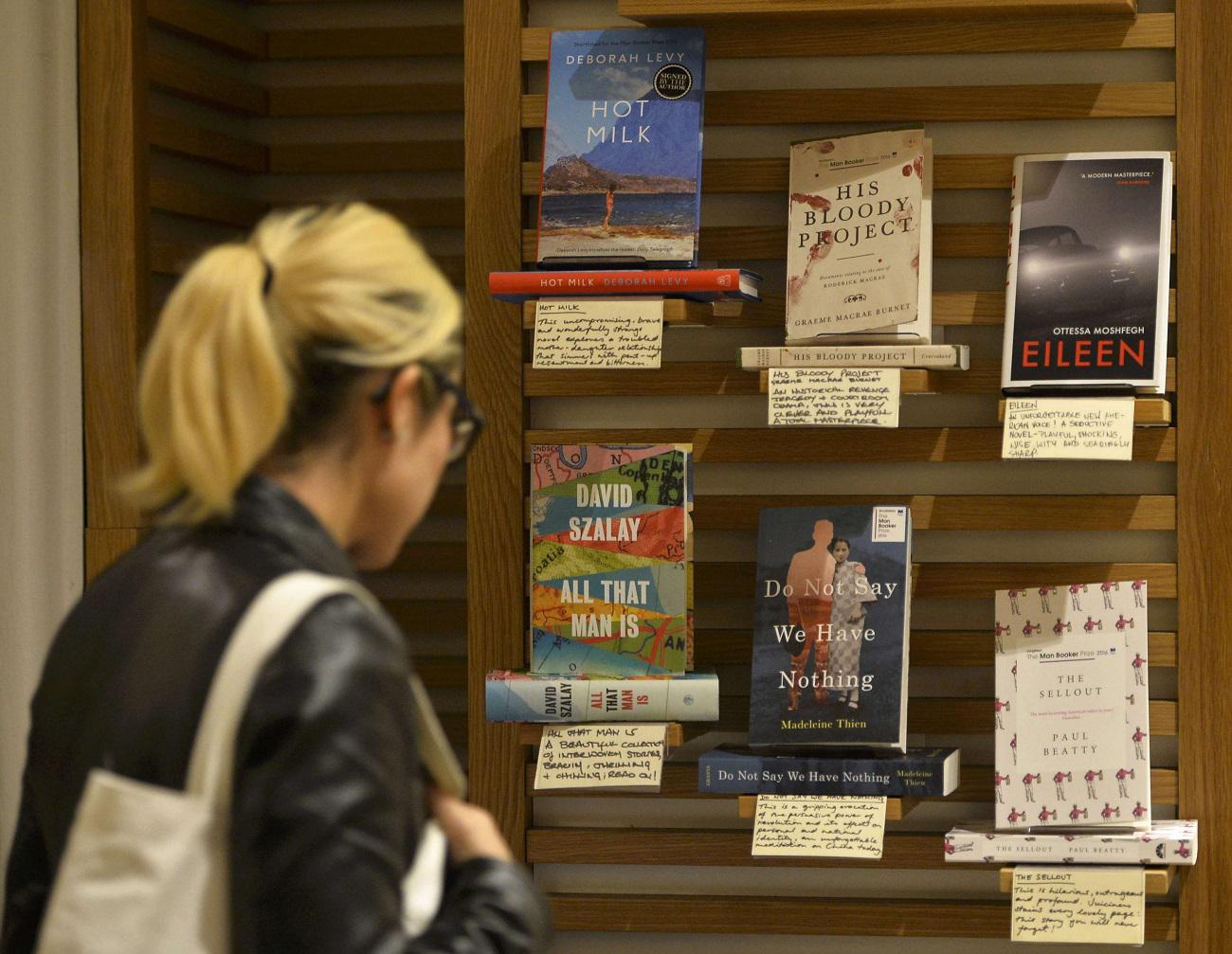 امرأة تنظر إلى قائمة الكتب القصيرة لجائزة مان بوكر في أحد متاجر الكتب بلندن