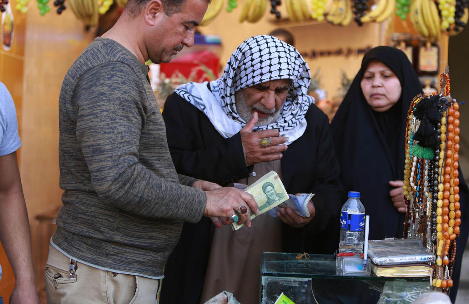 عراقي يستبدل عملة إيرانية في بغداد
