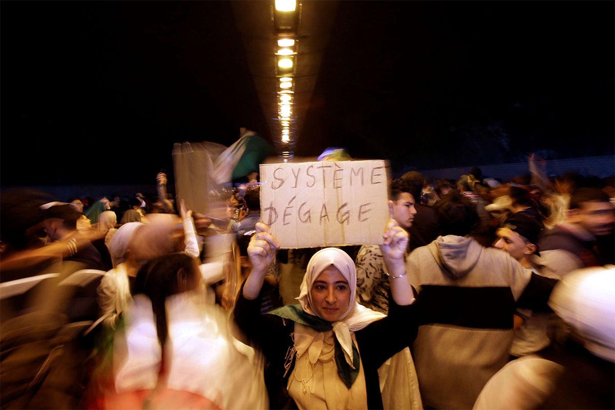 People take part in a protest demanding immediate political change in Algiers