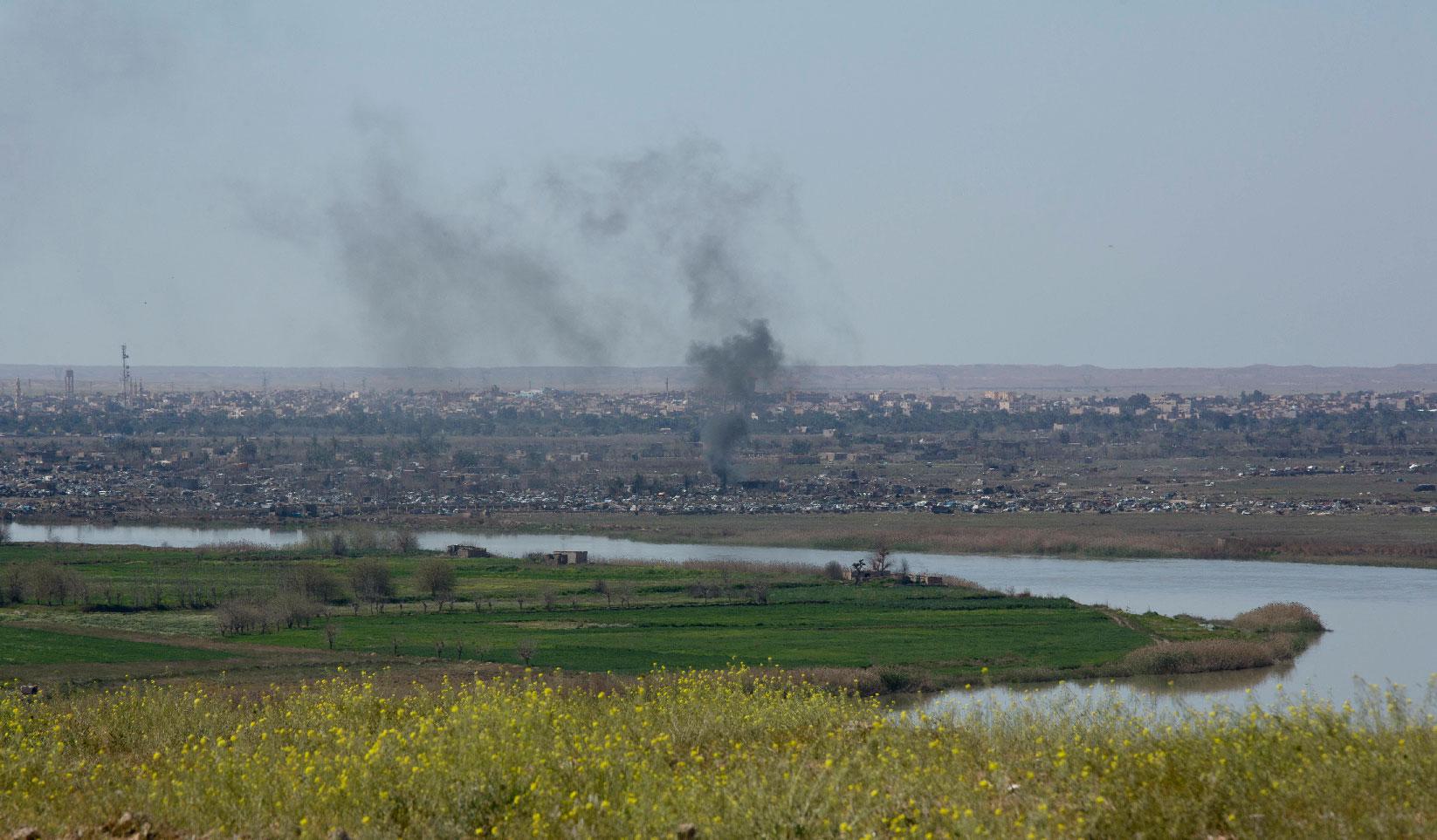 A column of smoke from operations by US-backed Syrian Democratic Forces (SDF) in Baghouz, the Islamic State group's last pocket of territory in Syria, Wednesday, March 20, 2019.