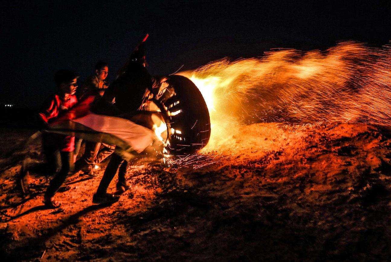 Palestinian protesters take part in a night demonstration near the fence along the border with Israel, in Rafah in the southern Gaza Strip, on March 19, 2019.